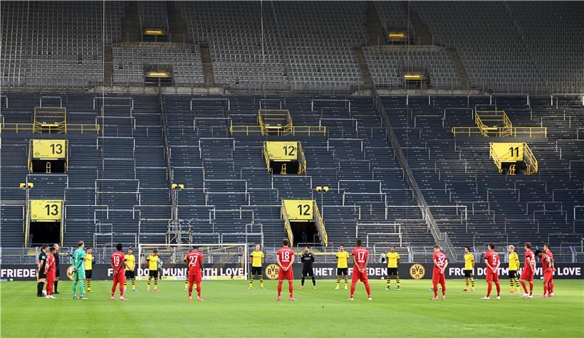 Die Spieler beider Mannschaften (Dortmund gelbes Trikot) gedenken mit einer Schweigeminute den Opfern der Corona-Pandemie.
