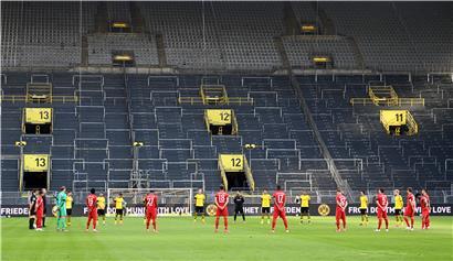 Die Spieler beider Mannschaften (Dortmund gelbes Trikot) gedenken mit einer Schweigeminute den Opfern der Corona-Pandemie.
