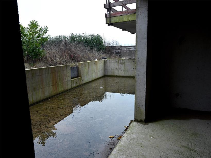 Terrasse eines unfertigen Neubaus steht unter Wasser, Käufer zahlen trotz Bauverzögerung Kreditraten