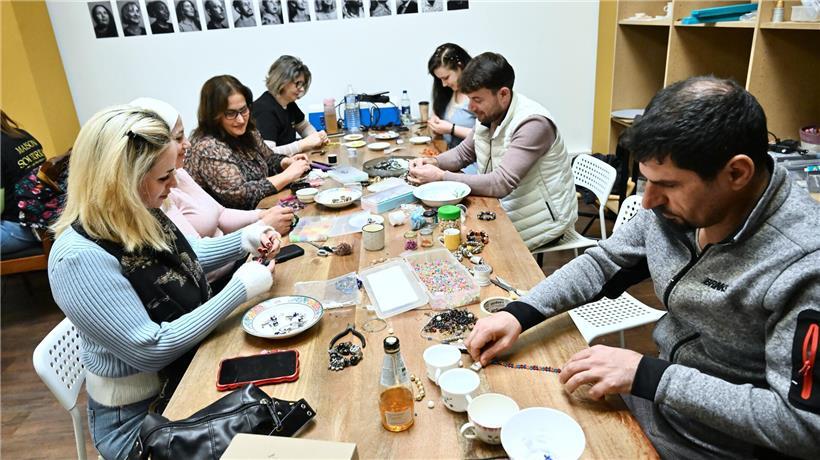 Werkstatt im Hinterraum eines Lokals mit Bastelmaterial, Nähmaschine und organisiertem Arbeitsplatz