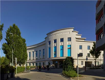  Die abgerundete Fassade im Art-déco-Stil mit dem Haupteingang
