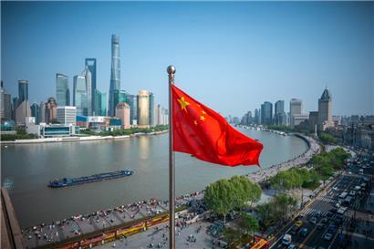 Die chinesische Flagge weht vor der Skyline von Shanghai
