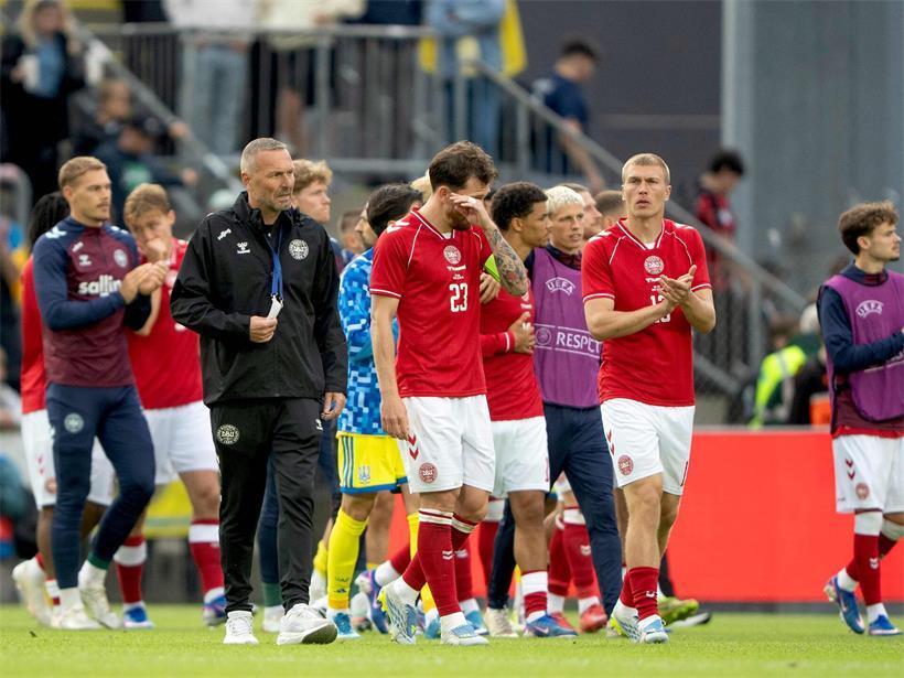 Dänische Fußballmannschaft am Sonntag nach Schockmoment auf dem Spielfeld stehend