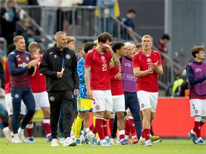 Dänische Fußballmannschaft am Sonntag nach Schockmoment auf dem Spielfeld stehend
