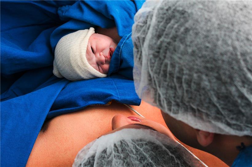 Die frischgebackenen Eltern sehen zum ersten Mal ihr Baby
