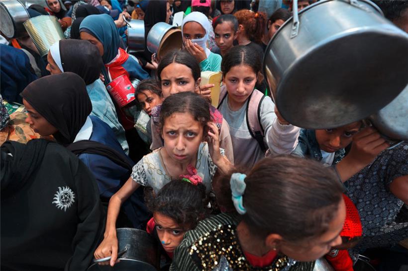 Die israelische Regierung von Benjamin Netanjahu entwürdigt die Menschen im Gazastreifen: Kinder im Flüchtlingslager Nuseirat im Zentrum von Gaza stehen für eine Mahlzeit an
