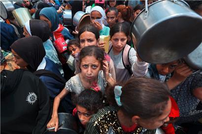 Die israelische Regierung von Benjamin Netanjahu entwürdigt die Menschen im Gazastreifen: Kinder im Flüchtlingslager Nuseirat im Zentrum von Gaza stehen für eine Mahlzeit an
