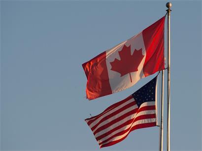 Die kanadische (oben) und die US-amerikanische Flagge sind auf dem Friedensbogen an der kanadisch-US-amerikanischen Grenze in Britisch-Kolumbien zu sehen. US-Präsident Donald Trump hat die Handelsgespräche mit Kanada für beendet erklärt. Als Grund nannte der Republikaner auf der Plattform Truth Social eine angeblich irreführende kanadische Werbekampagne gegen Zölle.