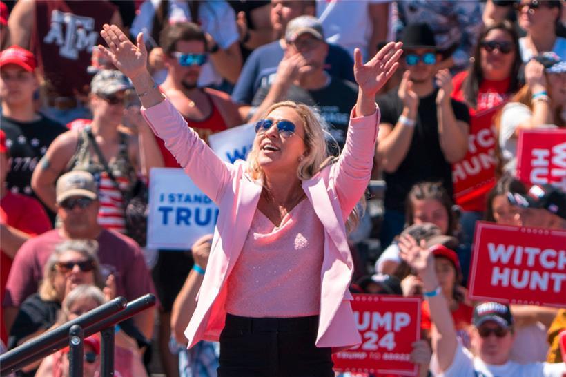 Die republikanische US-Abgeordnete Marjorie Taylor Greene aus Georgia winkt, als Trump sie erwähnt
