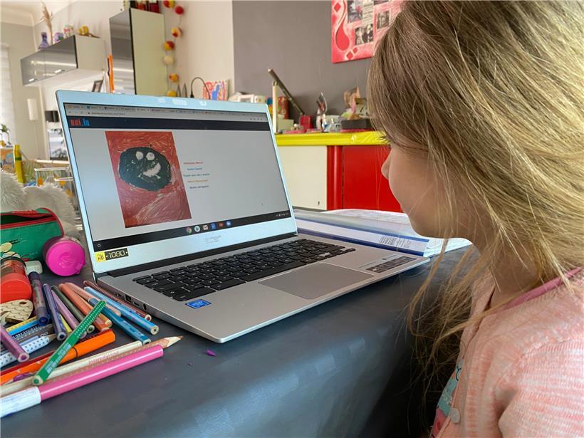 Die sechsjährige Elina sitzt am Laptop und hat mit ihrem Vater den Fragebogen zur Studie Covid-Kids von der Uni.lu ausgefüllt
