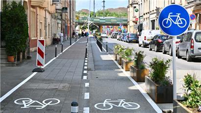 Die zu großen Blumenkästen wurden durch kleinere ersetzt, der Radweg stellenweise wegen der Betriebe verengt, zudem bekam das Restaurant seine Ladezone zurück. Anpassungen wurden bereits vorgenommen. Die Gefahrenstelle Randstein zwischen den Fahrradspuren wurde zwar nicht entschärft, aber immerhin mit Farbe (gestrichelte Linie) besser sichtbar gemacht.

