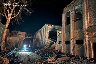 Dieses Foto, das vom ukrainischen Rettungsdienst am 29. Juli 2025 aufgenommen und veröffentlicht wurde, zeigt einen ukrainischen Polizeibeamten, der nach einem Luftangriff in Bilenke in der Region Saporischschja während der russischen Invasion in der Ukraine ein zerstörtes Gebäude der Strafkolonie Bilenkivska inspiziert
