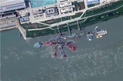 Dieses Satellitenbild von Planet Labs PBC zeigt Bergungsschiffe am Liegeplatz eines scheinbar gesunkenen, chinesischen U-Bootes in einer Werft in der Nähe von Wuhan
