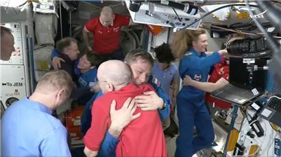 Dieses Standbild aus einem Video der NASA zeigt den Astronauten Don Pettit (M,unten) der Kirill Peskov umarmt, nachdem die SpaceX-Kapsel an die Internationale Raumstation (ISS) angedockt hat
