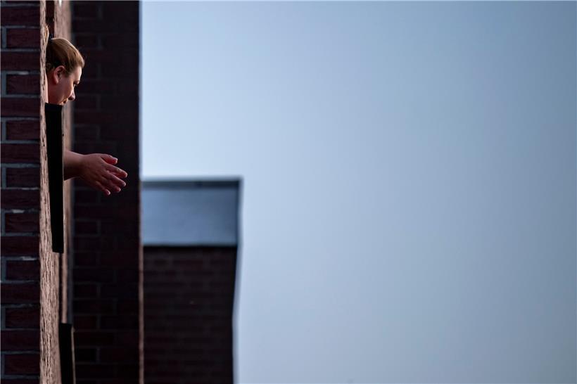 Dieses Symbolbild zeigt eine Frau, die von ihrem Apartment aus aus dem Fenster schaut. Eine Mutter hat uns berichtet, wie es ist, in einer Wohnung mit ihrem 11-jährigen Sohn die Quarantäne auszusitzen.

