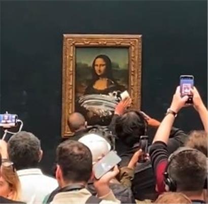 Dieses Videostandbild zeigt einen Mitarbeiter des Louvre, der Sahnekuchen von der Vitrine, die die Mona Lisa im Louvre-Museum schützt, wischt. Ein Besucher des Pariser Louvre hat die hinter Panzerglas ausgestellte „Mona Lisa“ mit einem Tortenstück beworfen. Das weltberühmte Gemälde von Leonardo da Vinci sei in seiner Schutzvitrine bei der Attacke am Sonntag aber nicht beschädigt…
