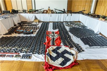 Dieses vom österreichischen Innenministerium veröffentlichte Bild zeigt sichergestellte Waffen, Munition und „Gegenstände nach dem Verbotsgesetz“, also NS-Fahnen
