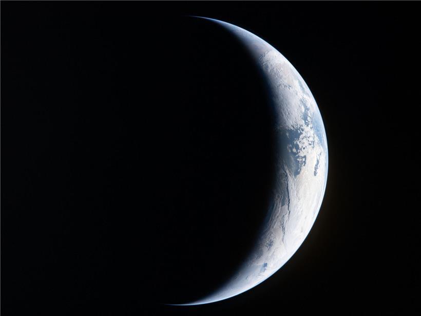 Astronaut der Artemis II betrachtet Erdstreifen durch Orion-Raumschiff-Fenster vor schwarzem Weltraum am 4. April 2026