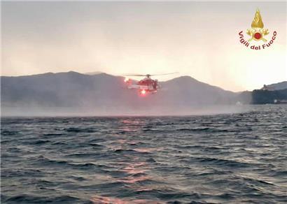 Dieses von der italienischen Feuerwehr veröffentlichten Bild zeigt einen Hubschrauber bei der Suche nach Vermissten, nachdem ein Touristen-Boot in einem Sturm auf dem italienischen Lago Maggiore gekentert ist
