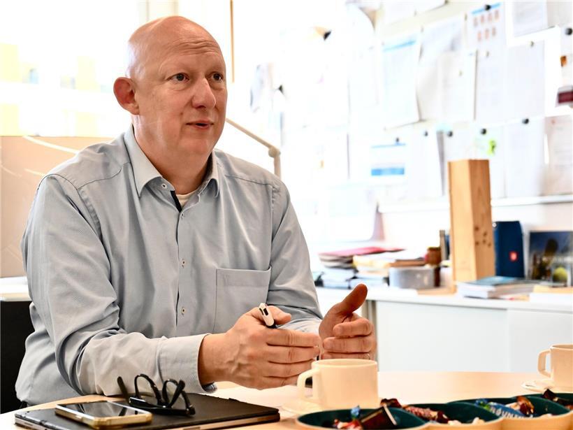 Porträt von Direktor Gérard Zens in formeller Kleidung vor neutralem Hintergrund