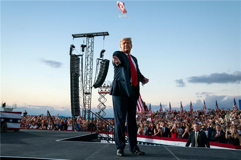 Donald Trump, Präsident der USA, wirft Gesichtsmasken in die Menge, als er zu einer Wahlkampfkundgebung am Orlando Sanford International Airport eintrifft
