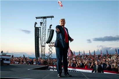 Donald Trump, Präsident der USA, wirft Gesichtsmasken in die Menge, als er zu einer Wahlkampfkundgebung am Orlando Sanford International Airport eintrifft
