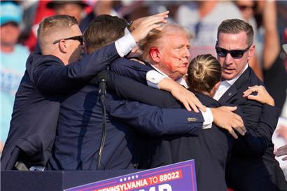 Donald Trump wird von Agenten des US-Geheimdienstes Secret Service umringt, als ihm bei einer Wahlkampfveranstaltung von der Bühne geholfen wird
