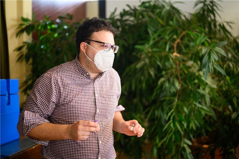 Dr. Enrico Randazzo mit zwei Ampullen des Biontech-Pfizer-Impfstoffes
