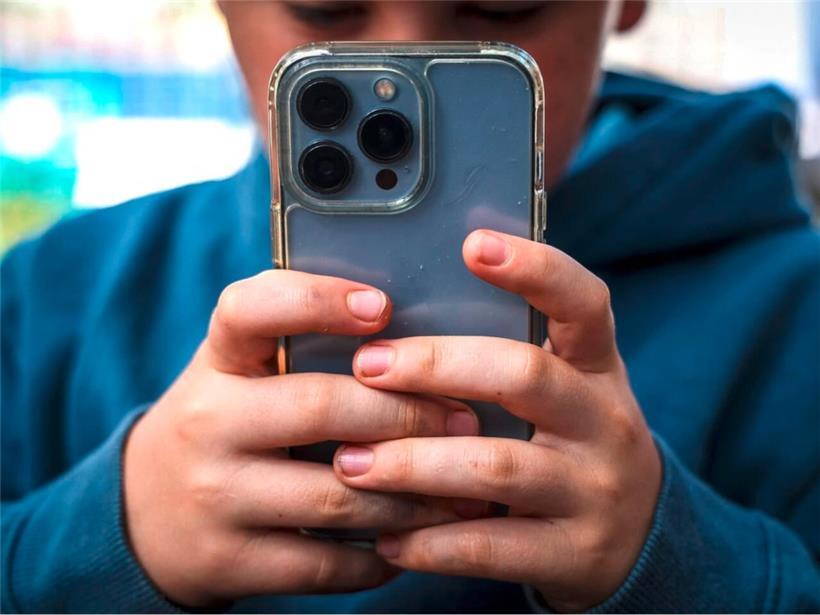 Ein 14-jähriger Junge daddelt auf seinem Handy im australischen Gosford
