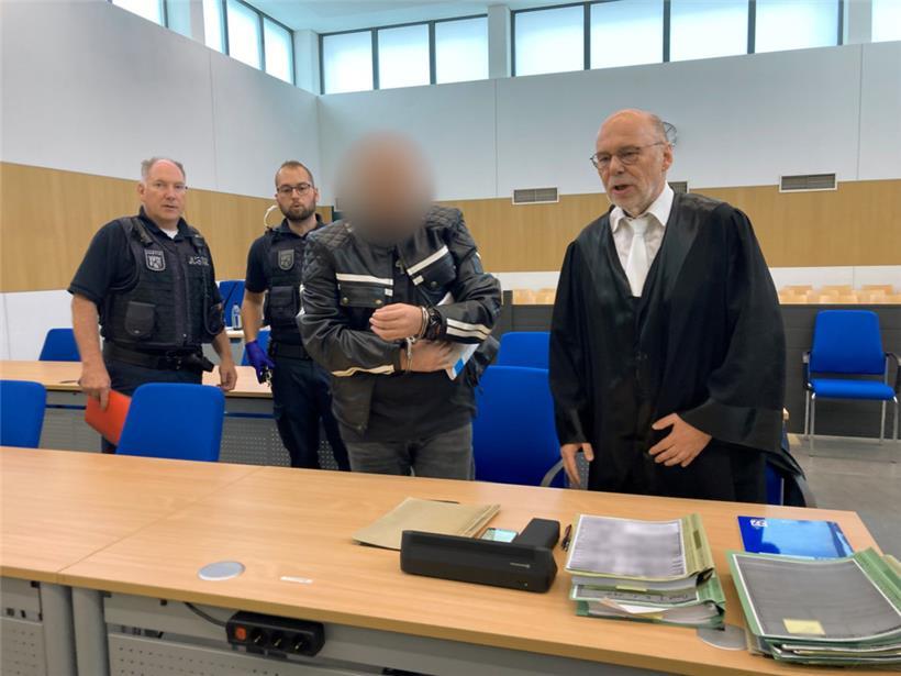 Ein 44-Jähriger (2.v.r.), der vom Fahrrad aus Passanten mit Steinen beworfen und teils schwer verletzt haben soll, kommt zu Prozessbeginn in den Gerichtssaal
