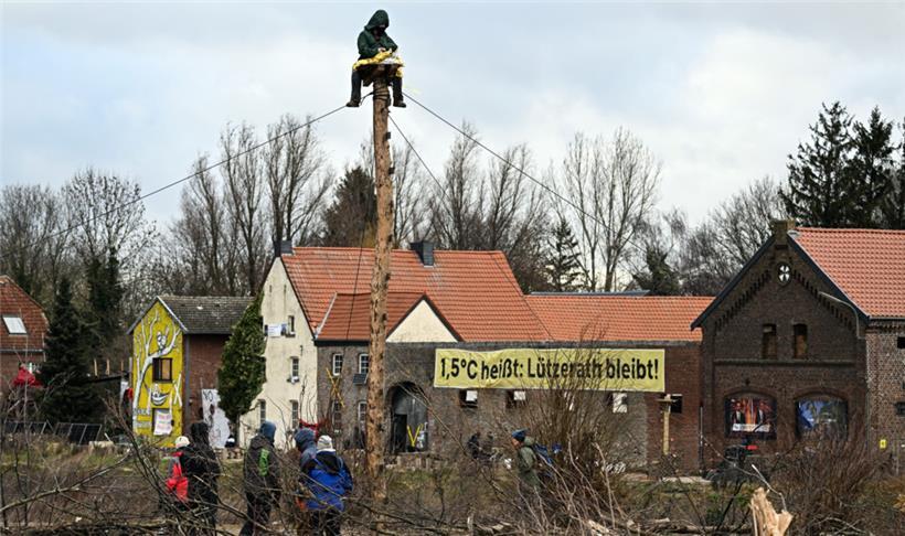 Ein Aktivist sitzt auf einem sogenannten Monopod in der Ortschaft Lützerath