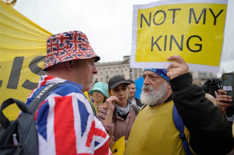 Ein Anti-Monarchie-Demonstrant (r), spricht mit einem Monarchie-Befürworter in der Nähe des Buckingham-Palastes. Gegen die Krönung von König Charles III. haben Menschen in mehreren britischen Städten demonstriert.
