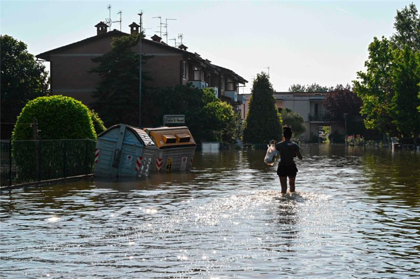 Ein Anwohner geht am 21. Mai 2023 in Conselice, in der Nähe von Ravenna, über eine überflutete Straße, nachdem die Region Emilia-Romagna von tödlichen Überschwemmungen heimgesucht wurde

