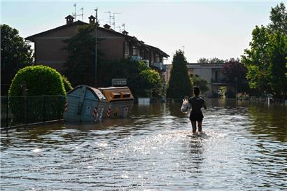 Ein Anwohner geht am 21. Mai 2023 in Conselice, in der Nähe von Ravenna, über eine überflutete Straße, nachdem die Region Emilia-Romagna von tödlichen Überschwemmungen heimgesucht wurde

