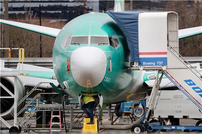 Ein Arbeiter inspiziert eine Boeing 737 MAX. 
