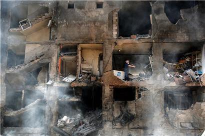 Arbeiter bergen Kisten aus zerstörtem Gebäude in von israelischen Angriffen auf Beirut betroffenem Gebiet