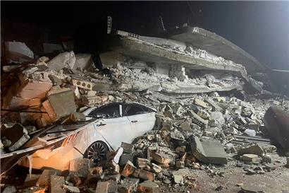 Ein Auto ist unter den Trümmern eines eingestürzten Gebäudes in der Stadt Azmarin in der nordsyrischen Provinz Idlib zu sehen
