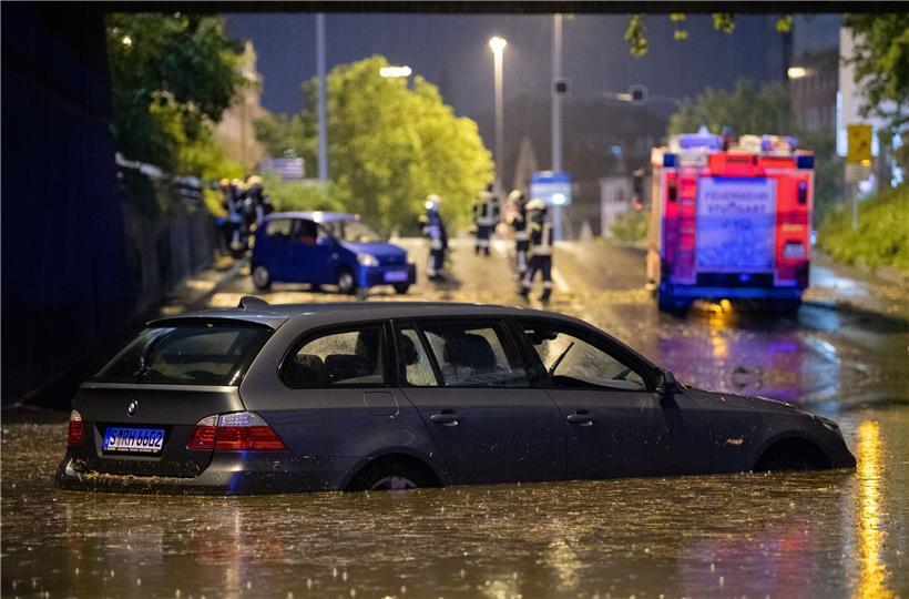 Ein Auto steht in der überfluteten Autounterführung am Österreichischen Platz in Stuttgart
