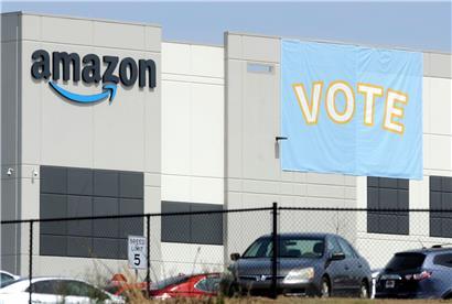 Ein Banner mit der Aufschrift „Vote“, das die Arbeiter dazu auffordert, an den Gewerkschaftswahlen teilzunehmen, ist an einem Amazon-Lagerhaus zu sehen
