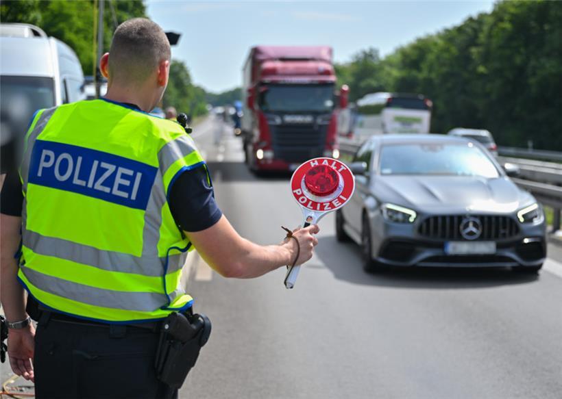 Ein Beamter der Bundespolizei stoppt ein Auto auf der A12

