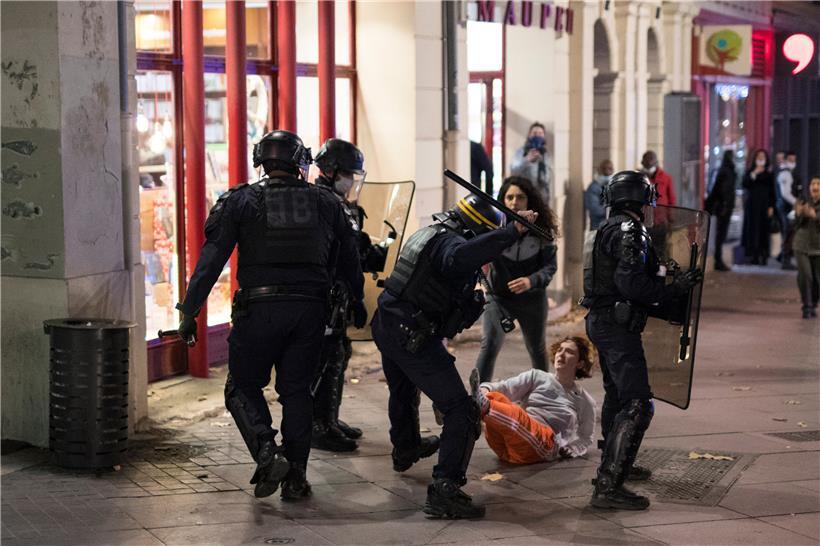 Ein Bereitschaftspolizist schlägt während eines Protestes gegen ein neues Sicherheitsgesetz in Marseille mit einem Schlagstock nach einer Teilnehmerin einer Demo. Kritiker eines vorgeschlagenen französischen Sicherheitsgesetzes, das den Austausch von Bildern von Polizisten einschränken würde, versammeln sich aus Protest im ganzen Land.
