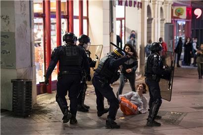 Ein Bereitschaftspolizist schlägt während eines Protestes gegen ein neues Sicherheitsgesetz in Marseille mit einem Schlagstock nach einer Teilnehmerin einer Demo. Kritiker eines vorgeschlagenen französischen Sicherheitsgesetzes, das den Austausch von Bildern von Polizisten einschränken würde, versammeln sich aus Protest im ganzen Land.
