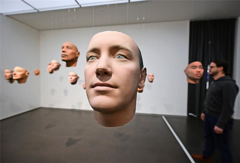 Ein Besucher steht im Kunstmuseum Stuttgart in der Ausstellung mit dem Titel: „SHIFT. KI und eine zukünftige Gemeinschaft“. Gezeigt werden 3D-Drucke von Gesichtern, die von einer Software generiert wurden. 
