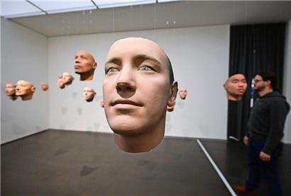 Ein Besucher steht im Kunstmuseum Stuttgart in der Ausstellung mit dem Titel: „SHIFT. KI und eine zukünftige Gemeinschaft“. Gezeigt werden 3D-Drucke von Gesichtern, die von einer Software generiert wurden. 
