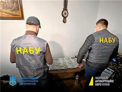 Ein Bild vom 23. Januar zeigt Mitglieder des nationalen Antikorruptionsbüros der Ukraine vor beschlagnahmten Geldscheinen
