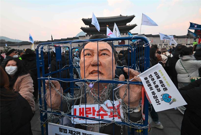 Ein Bildnis des angeklagten südkoreanischen Präsidenten Yoon Suk-yeol ist in einer Gefängnisattrappe zu sehen, während Demonstranten in Seoul an einem Protest teilnehmen.
