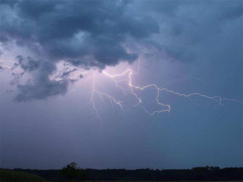 Blitz bei Sommergewitter am Abendhimmel mit dunklen Wolken und leuchtendem Gewitterlicht