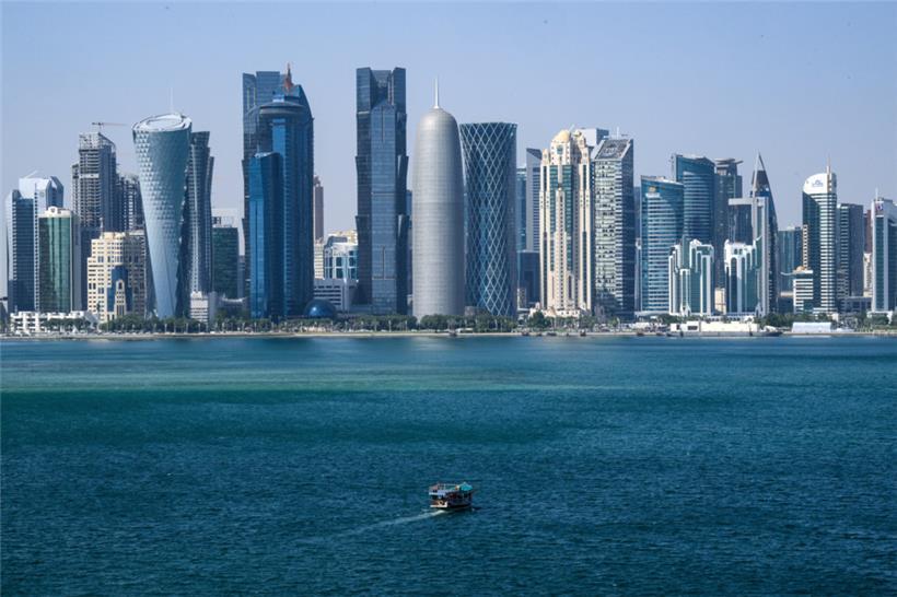 Ein Boot fährt vor der Skyline von Doha (Katar) vorbei
