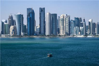 Ein Boot fährt vor der Skyline von Doha (Katar) vorbei
