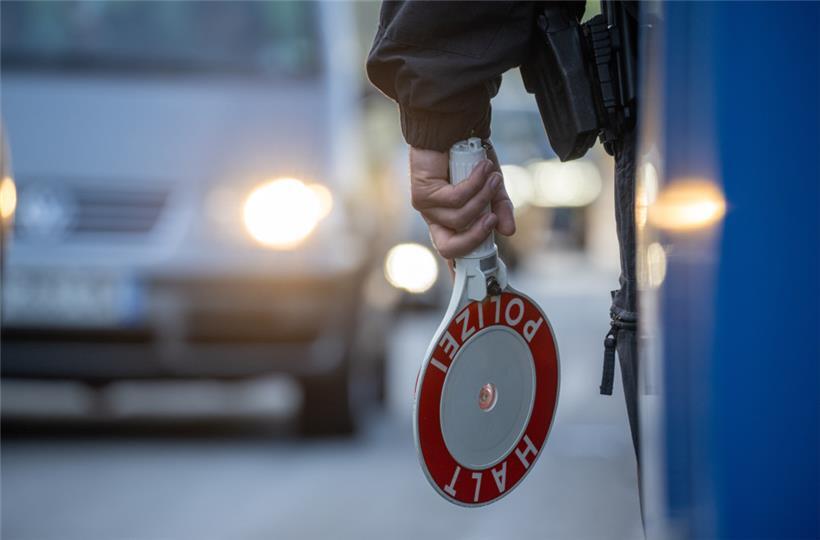 Ein Bundespolizist steht mit einer Kelle an einer Kontrollstelle auf der A64 bei Trier
